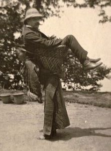 A British merchant being carried by a Sikkimese woman. West Bengal, ca. 1903.